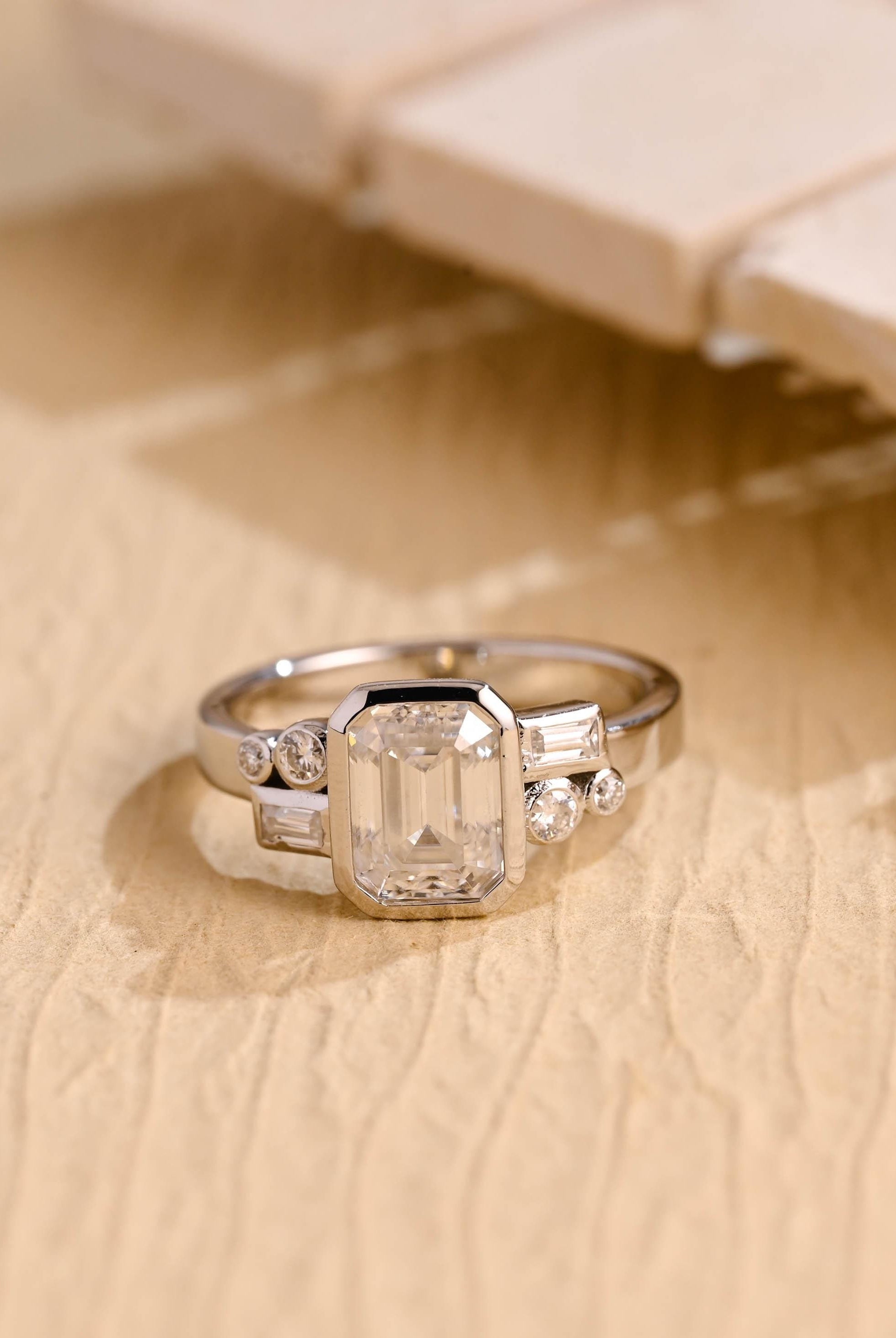 1 carat emerald cut bezel cluster engagement ring moissanite
