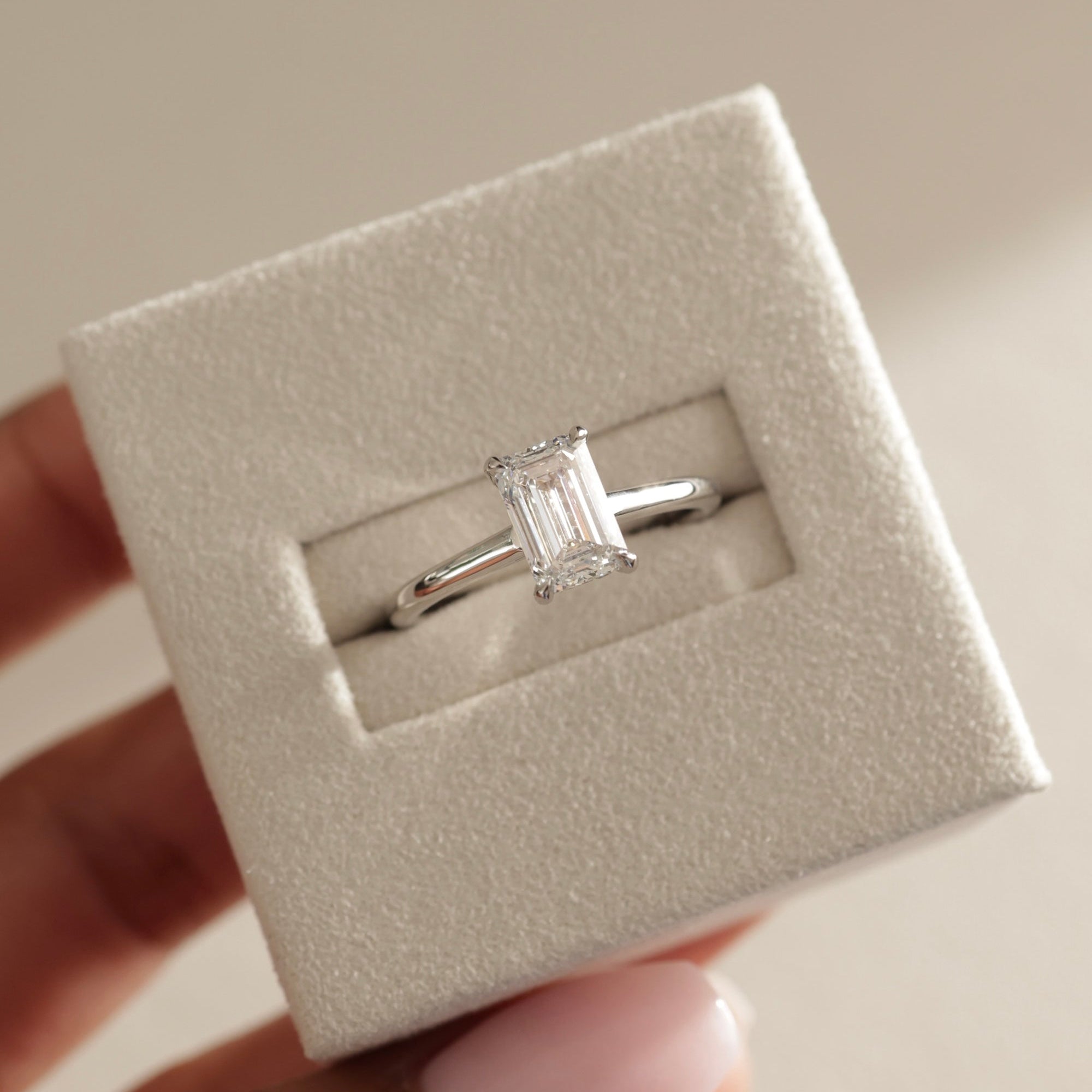 modern emerald cut ring, emerald cut diamond gold band, emerald cut prong setting, emerald diamond with side stones, hidden halo engagement ring, yellow gold hidden halo ring, hidden halo ring for her, floating hidden halo diamond ring, hidden halo with side stones