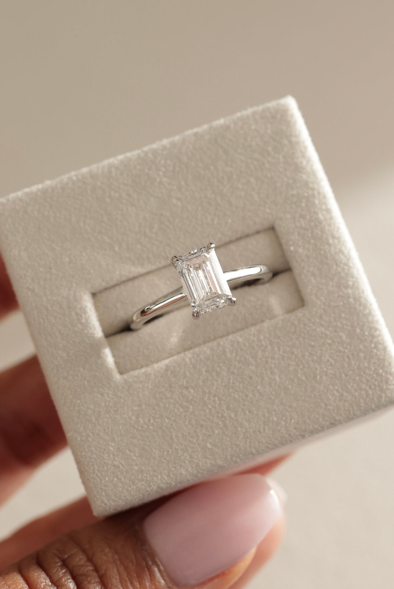 modern emerald cut ring, emerald cut diamond gold band, emerald cut prong setting, emerald diamond with side stones, hidden halo engagement ring, yellow gold hidden halo ring, hidden halo ring for her, floating hidden halo diamond ring, hidden halo with side stones