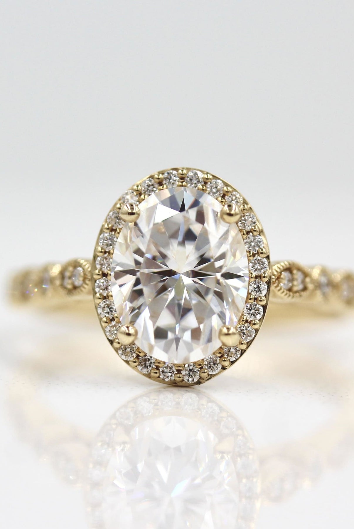 Vintage-inspired three-stone moissanite engagement rings with side stones