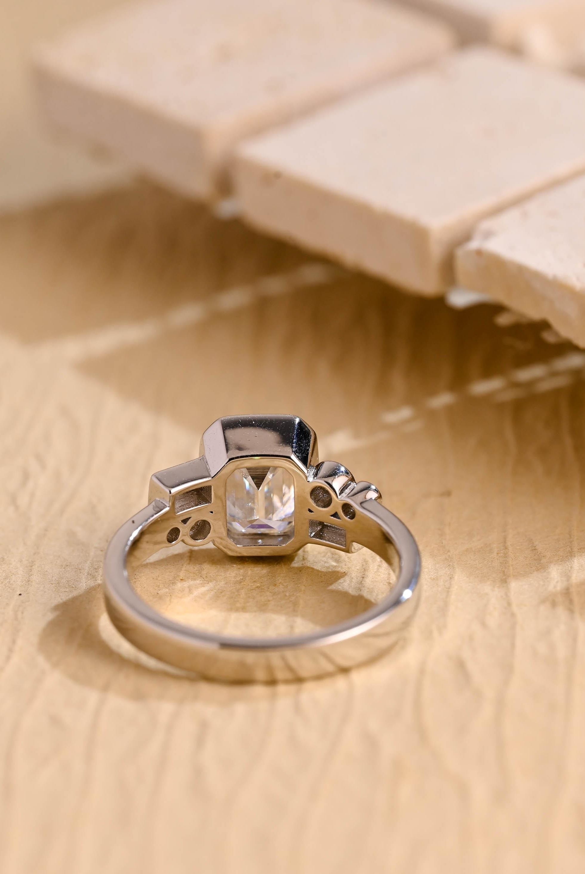 modern emerald cut bezel cluster engagement ring moissanite