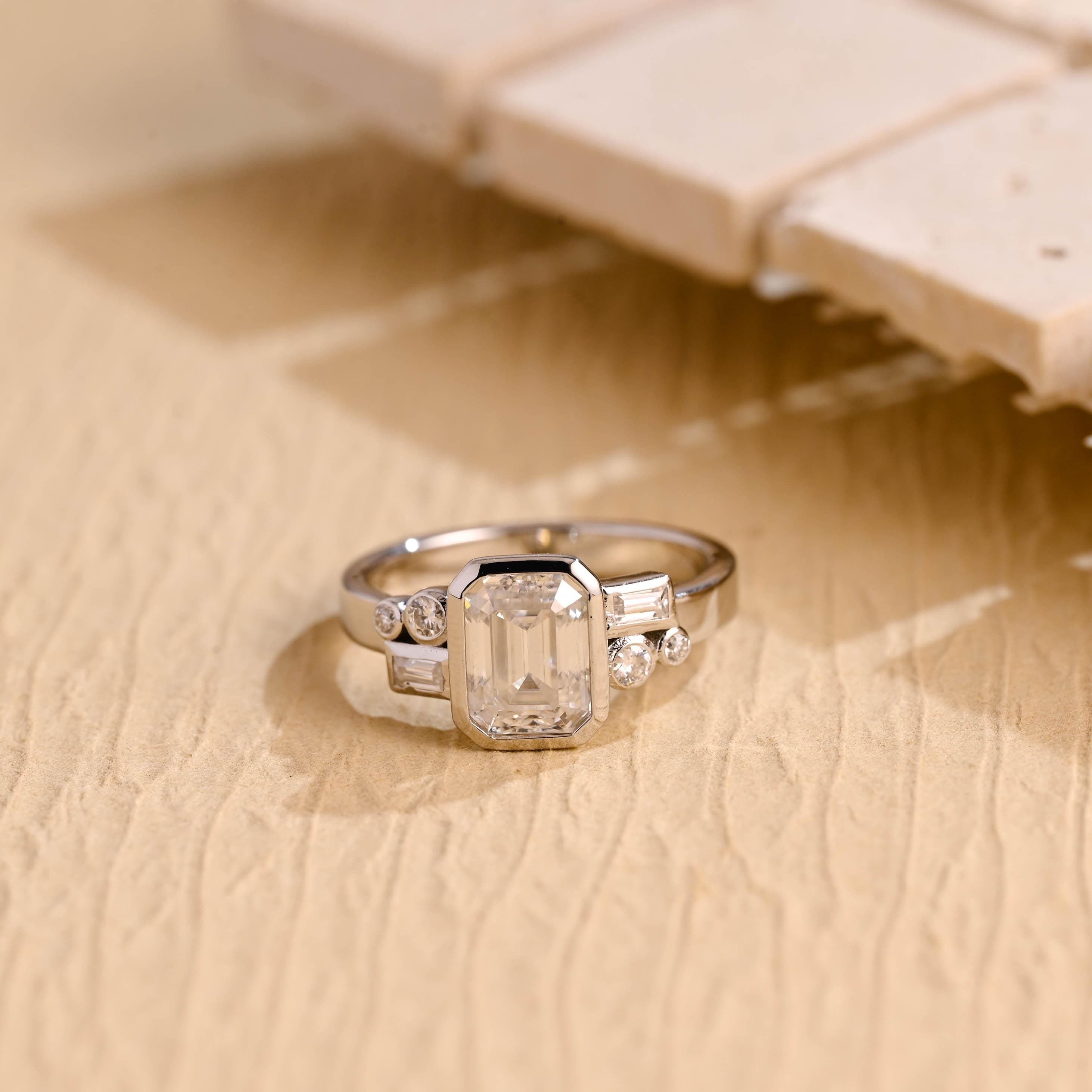 1 carat emerald cut bezel cluster engagement ring moissanite