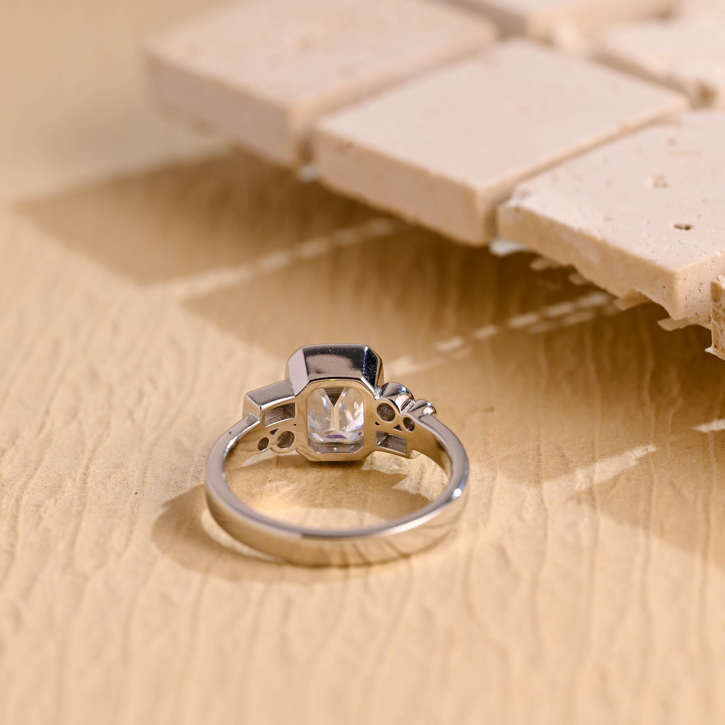 modern emerald cut bezel cluster engagement ring moissanite